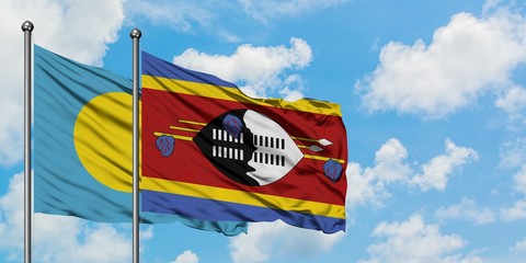 Palau and Swaziland flag waving in the wind against white cloudy blue sky together. Diplomacy...