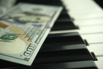  one hundred dollars on a piano keyboard close up     