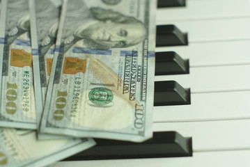 one hundred dollars on a piano keyboard