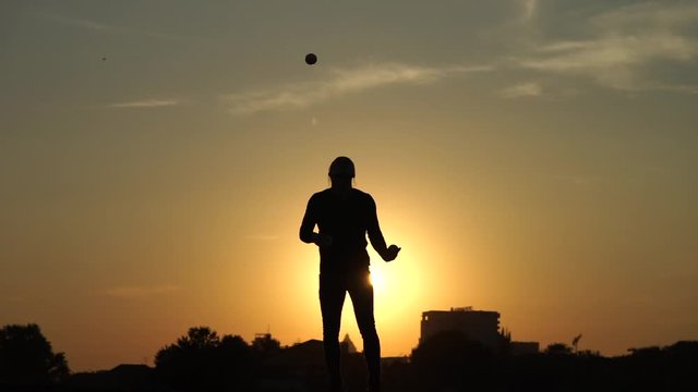Circus artist juggling with balls on colorful sunset