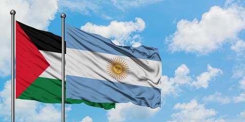Palestine and Argentina flag waving in the wind against white cloudy blue sky together. Diplomacy concept, international relations.