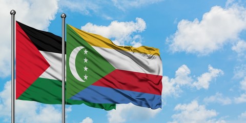 Palestine and Comoros flag waving in the wind against white cloudy blue sky together. Diplomacy...