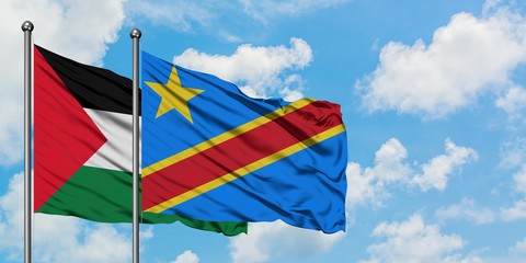 Palestine and Congo flag waving in the wind against white cloudy blue sky together. Diplomacy...