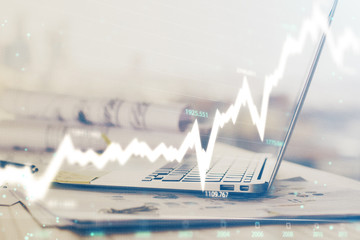 Forex graph hologram on table with computer background. Multi exposure. Concept of financial markets.