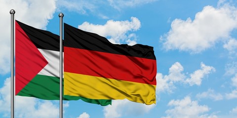 Palestine and Germany flag waving in the wind against white cloudy blue sky together. Diplomacy concept, international relations.