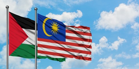 Palestine and Malaysia flag waving in the wind against white cloudy blue sky together. Diplomacy concept, international relations.