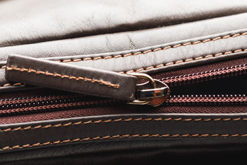 zipper of brown leather bag, close-up view