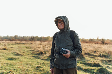 Mature man photographing the autumn season.