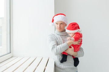 Obraz premium Koncepcja ojcostwa i świąt - ojciec z jego chłopcem w czapkach Mikołaja obchodzi Boże Narodzenie