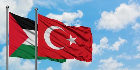 Palestine and Turkey flag waving in the wind against white cloudy blue sky together. Diplomacy concept, international relations.