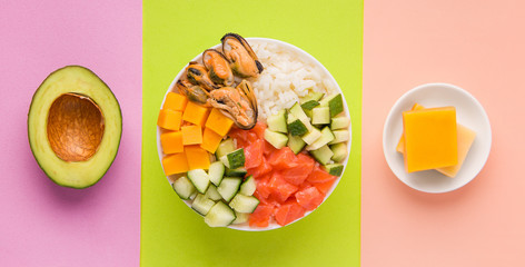 Poke salad with rice, salmon, tuna, avocado, mussels, cucumber and cheese. Hawaiian cuisine. Japanese food. Diced Salad.