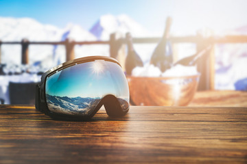 Fototapeta apres ski - goggles with mountains reflection on the restaurant table at ski resort obraz