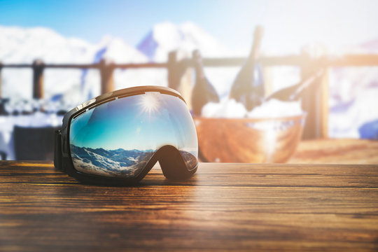 apres ski - goggles with mountains reflection on the restaurant table at ski resort
