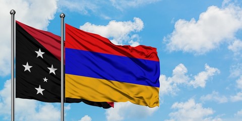 Papua New Guinea and Armenia flag waving in the wind against white cloudy blue sky together. Diplomacy concept, international relations.