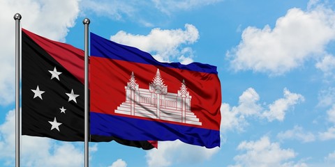 Papua New Guinea and Cambodia flag waving in the wind against white cloudy blue sky together. Diplomacy concept, international relations.