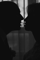silhouette of a couple in love with wedding rings, black and white photo, selective focus, film and grain photo