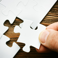 Hand with missing jigsaw puzzle piece. Business concept image for completing the final puzzle piece