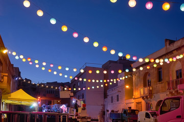 City street decorated with glowing colored lanterns to celebrate festival Ramadan, Indian diwali...