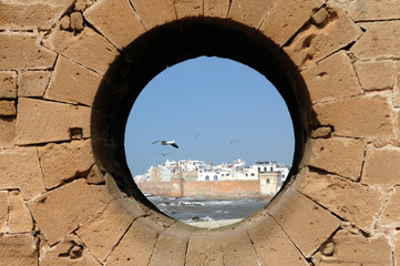 The ancient ramparts of the coastal town of Essaouira, Morocco. The fortress walls surround the old medina of Essaouira. The town is famous for its blue colours, especially the blue fishing boats.