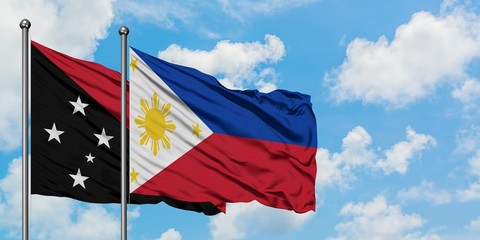 Papua New Guinea and Philippines flag waving in the wind against white cloudy blue sky together. Diplomacy concept, international relations.