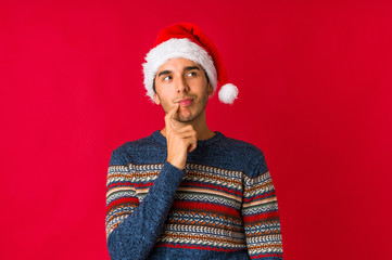 Young man on christmas day touches tummy, smiles gently, eating and satisfaction concept.