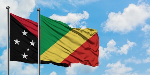 Papua New Guinea and Republic Of The Congo flag waving in the wind against white cloudy blue sky together. Diplomacy concept, international relations.