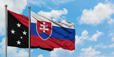 Papua New Guinea and Slovakia flag waving in the wind against white cloudy blue sky together. Diplomacy concept, international relations.