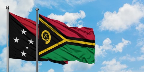 Papua New Guinea and Vanuatu flag waving in the wind against white cloudy blue sky together....