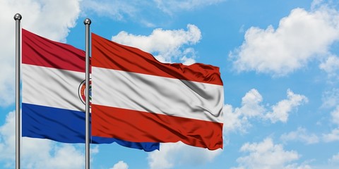 Paraguay and Austria flag waving in the wind against white cloudy blue sky together. Diplomacy concept, international relations.