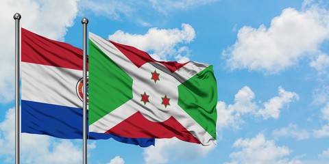 Paraguay and Burundi flag waving in the wind against white cloudy blue sky together. Diplomacy...