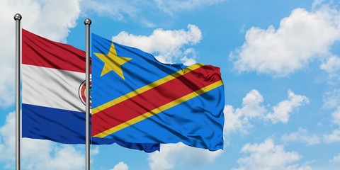 Paraguay and Congo flag waving in the wind against white cloudy blue sky together. Diplomacy...