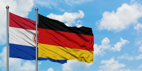 Paraguay and Germany flag waving in the wind against white cloudy blue sky together. Diplomacy concept, international relations.
