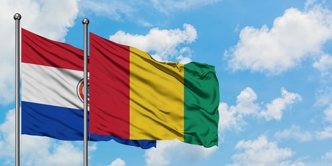 Paraguay and Guinea flag waving in the wind against white cloudy blue sky together. Diplomacy concept, international relations.