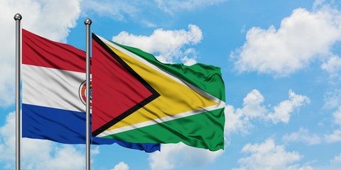 Paraguay and Guyana flag waving in the wind against white cloudy blue sky together. Diplomacy...