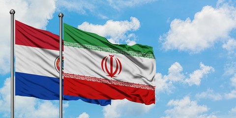 Paraguay and Iran flag waving in the wind against white cloudy blue sky together. Diplomacy concept, international relations.