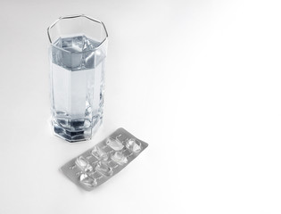 A glass of water and an empty blister as a concept of preserving health and medicine.