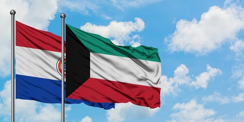 Paraguay and Kuwait flag waving in the wind against white cloudy blue sky together. Diplomacy concept, international relations.