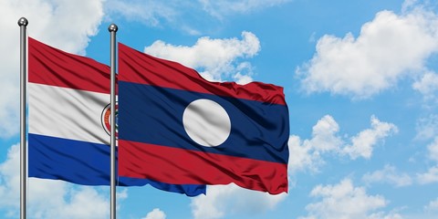 Paraguay and Laos flag waving in the wind against white cloudy blue sky together. Diplomacy concept, international relations.