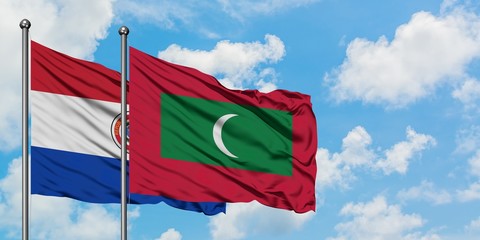 Paraguay and Maldives flag waving in the wind against white cloudy blue sky together. Diplomacy concept, international relations.