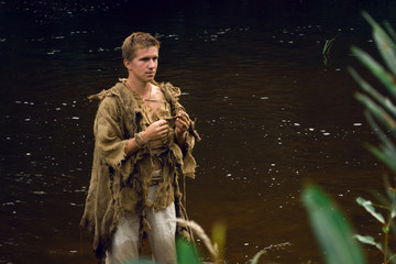 Medieval peasant man in river - downshifting concept