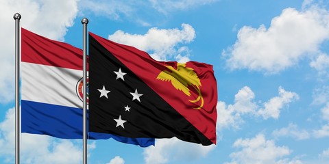 Paraguay and Papua New Guinea flag waving in the wind against white cloudy blue sky together. Diplomacy concept, international relations.