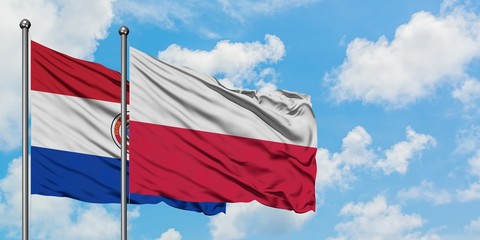 Paraguay and Poland flag waving in the wind against white cloudy blue sky together. Diplomacy concept, international relations.