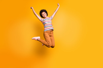 Fototapeta na wymiar Full length body size photo of cheerful rejoicing curly wavy casual beautiful youngster ecstatic about buying new orange trousers striped t-shirt isolated bright color background