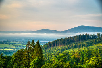 sunrise beautifully illuminating landscape with fog in the background mountains