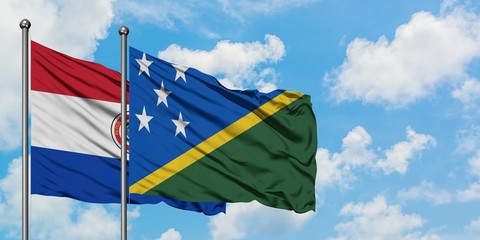 Paraguay and Solomon Islands flag waving in the wind against white cloudy blue sky together. Diplomacy concept, international relations.