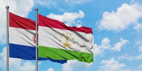 Paraguay and Tajikistan flag waving in the wind against white cloudy blue sky together. Diplomacy concept, international relations.