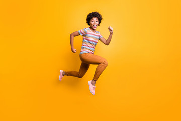 Fototapeta na wymiar Full body profile photo of jumping high dark skin wavy lady speed race running champion wear casual summer clothes isolated bright yellow color background