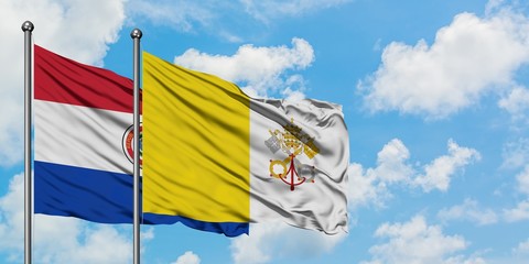 Paraguay and Vatican City flag waving in the wind against white cloudy blue sky together. Diplomacy concept, international relations.