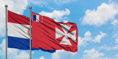 Paraguay and Wallis And Futuna flag waving in the wind against white cloudy blue sky together....