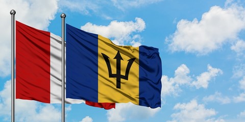 Peru and Barbados flag waving in the wind against white cloudy blue sky together. Diplomacy concept, international relations.